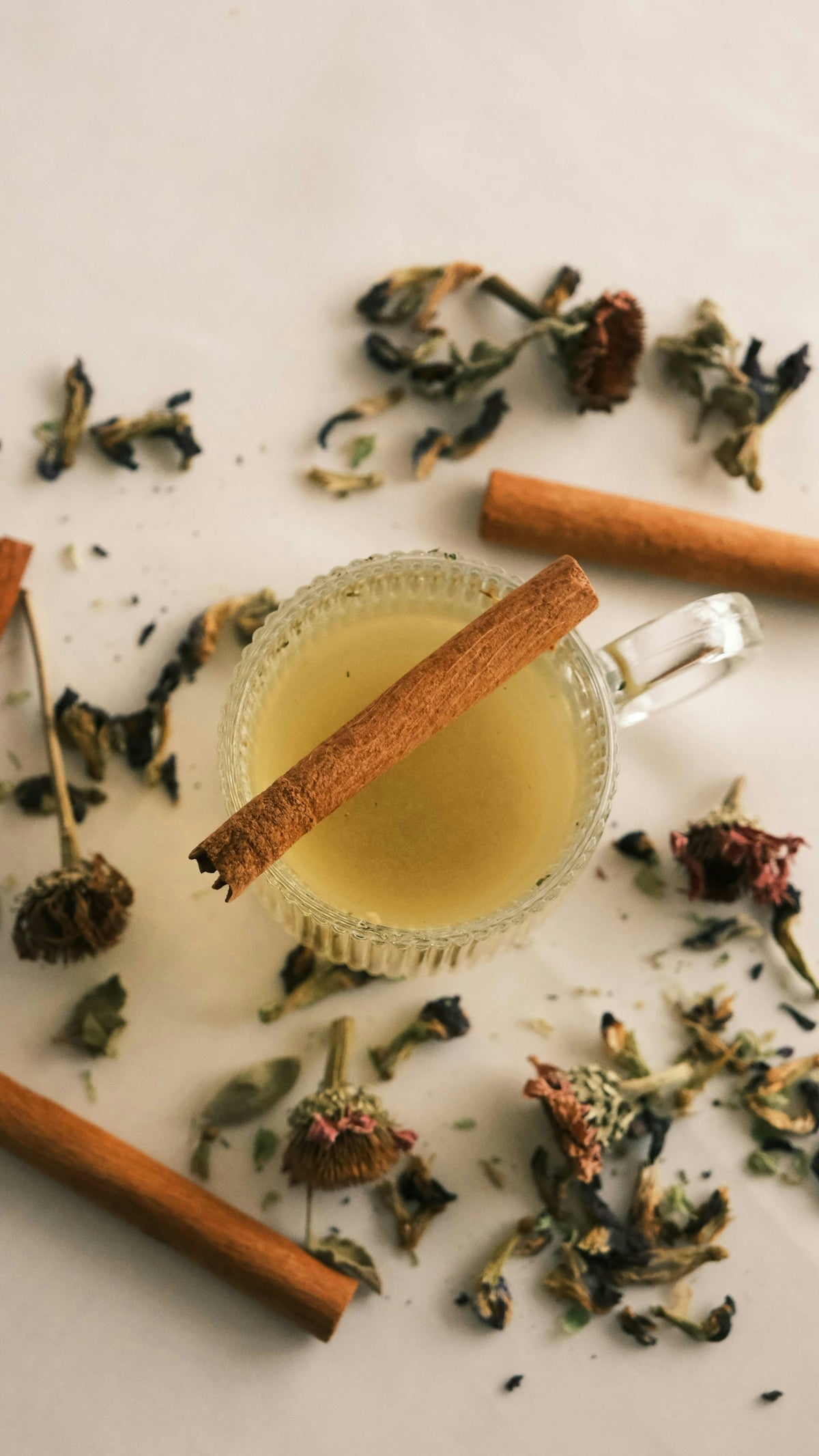 A cup of tea with a cinnamon stick next to it