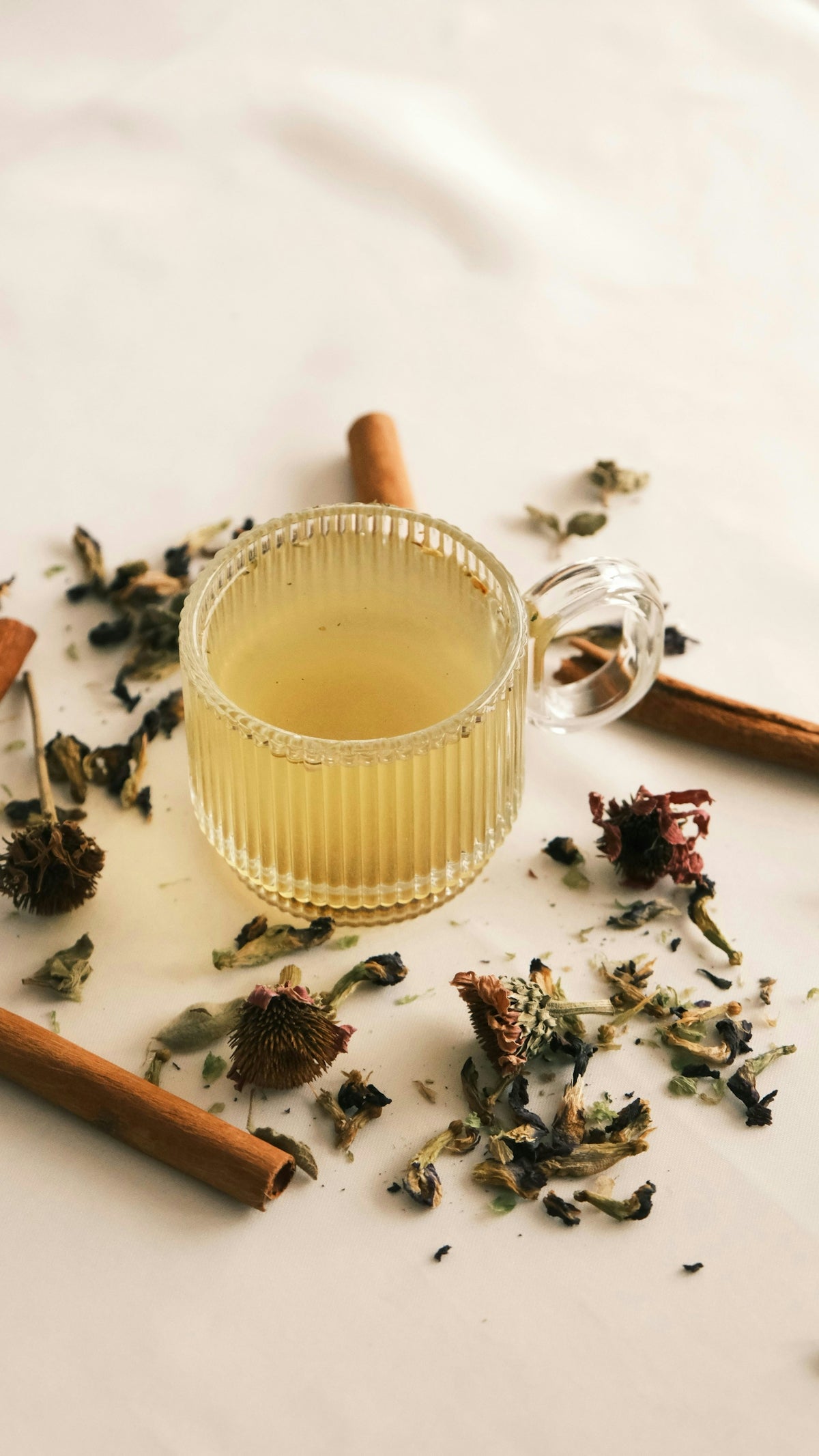 A cup of tea next to some cinnamon sticks